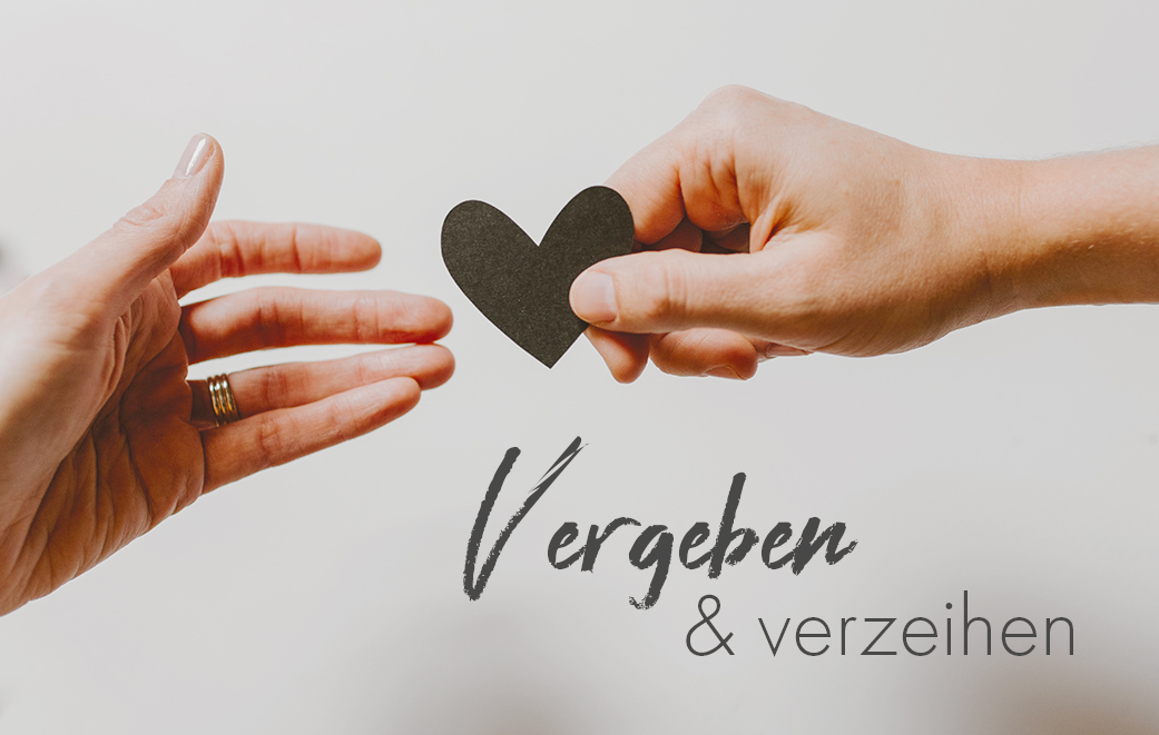 Eine Hand, die ein ausgeschnittenes Papier-Herz einer anderen Hand reicht als Blogbild für Vergeben und Verzeihen