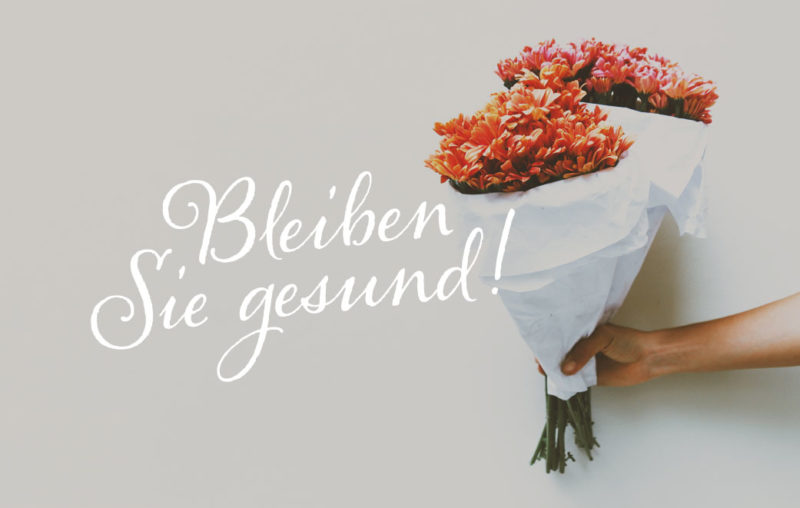 Hand mit zwei eingepackten Blumensträuße als Blogbild für Beiben Sie gesund!